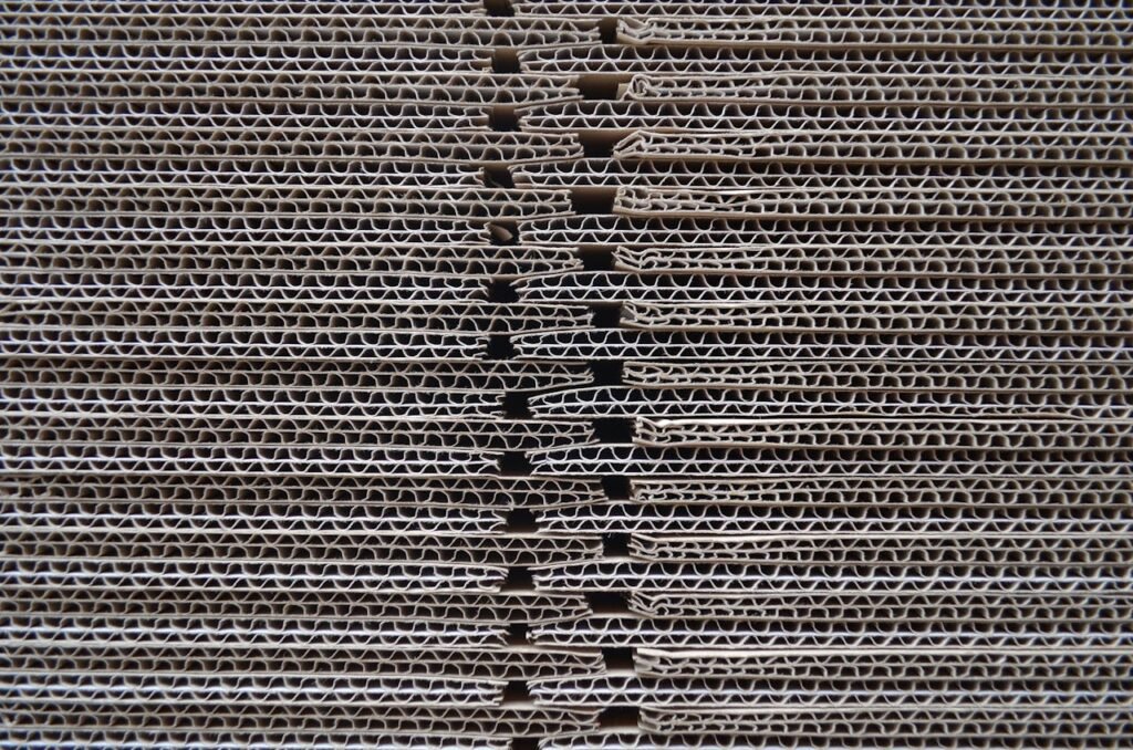 pexels-photo-28316095 Detailed close-up of corrugated cardboard stack showcasing its wavy texture and pattern.